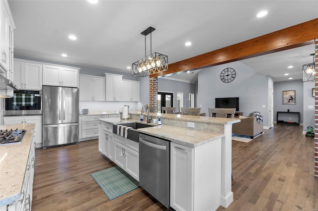 kitchen with dark hardwood / wood-style floors, a kitchen island with sink, stainless steel appliances, white cabinets, and beam ceiling