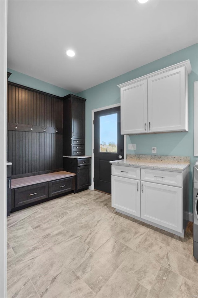 kitchen featuring light stone countertops, white cabinetry, and light tile flooring