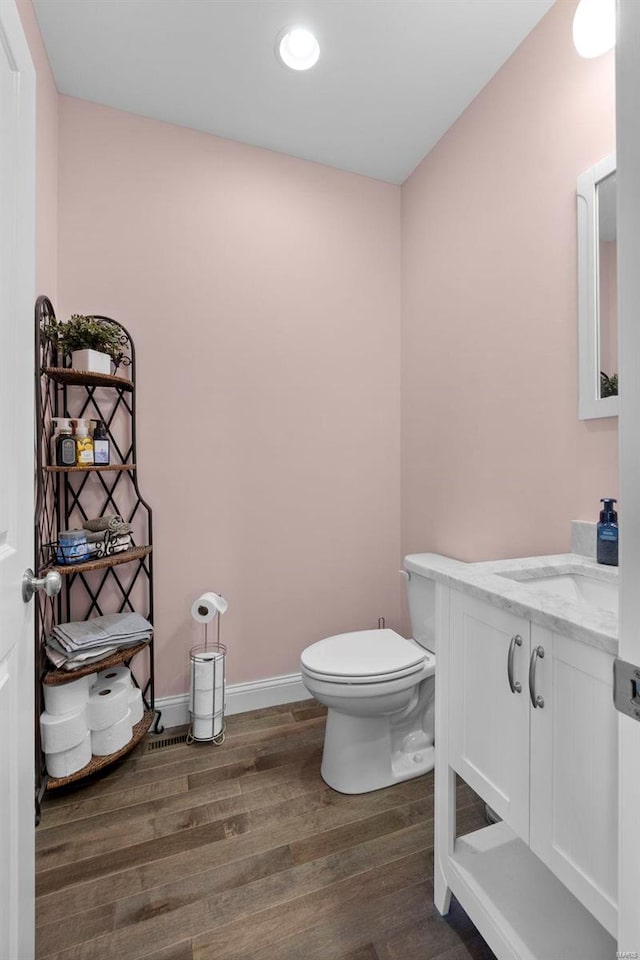 bathroom featuring vanity, wood-type flooring, and toilet