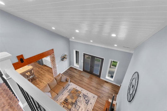 living room with a towering ceiling, dark wood-type flooring, and french doors