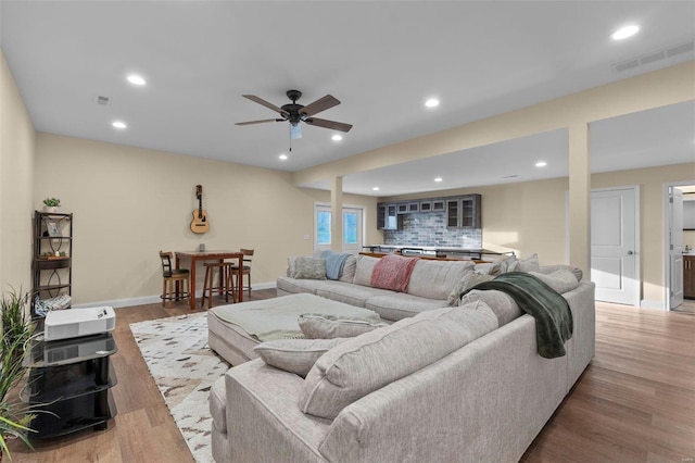 living room with wood-type flooring and ceiling fan