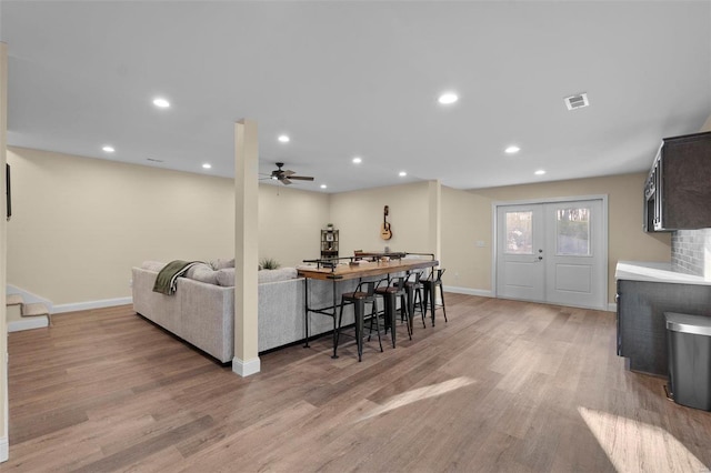 living room with french doors, light hardwood / wood-style floors, and ceiling fan