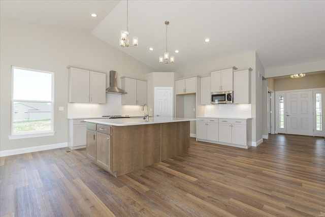 kitchen featuring white cabinets, a center island with sink, dark hardwood / wood-style flooring, and wall chimney exhaust hood