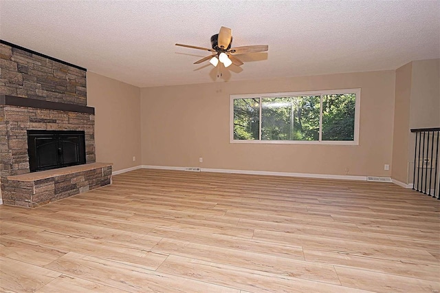 unfurnished living room featuring a textured ceiling and light hardwood / wood-style flooring