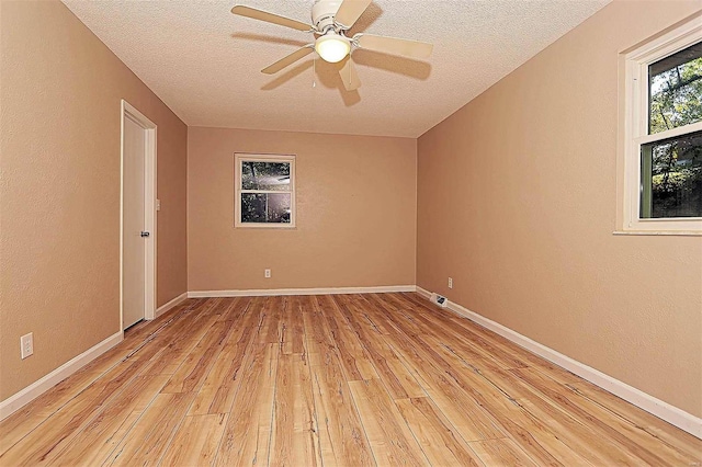 empty room with ceiling fan, a textured ceiling, and light wood-type flooring