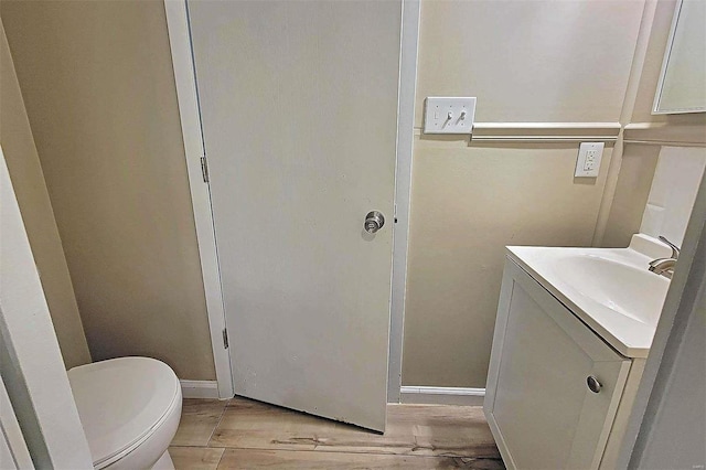 bathroom featuring vanity, toilet, and hardwood / wood-style flooring