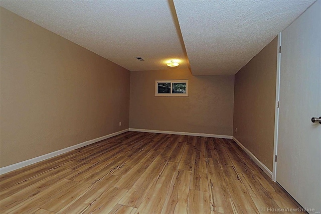 basement with wood-type flooring and a textured ceiling