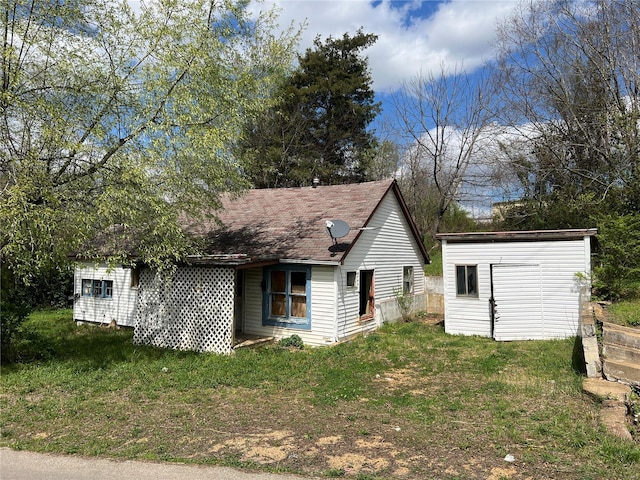 view of front of house featuring a storage unit and a front yard