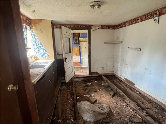 miscellaneous room featuring a textured ceiling and sink