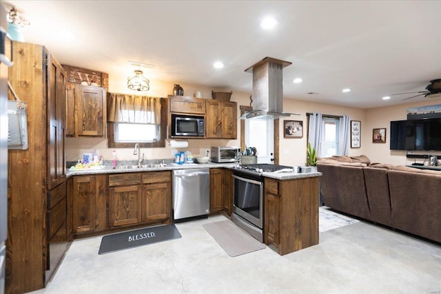 kitchen featuring island exhaust hood, ceiling fan, stainless steel appliances, and a wealth of natural light