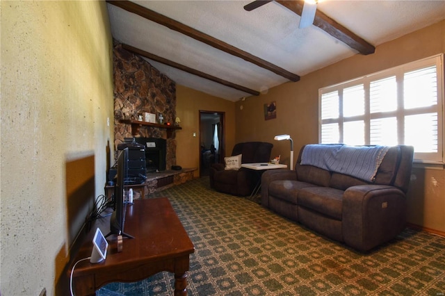 living room with lofted ceiling with beams, ceiling fan, a fireplace, and a textured ceiling