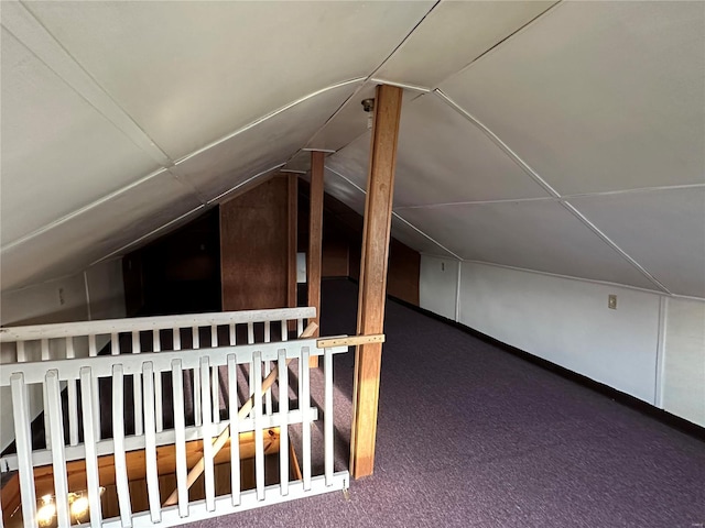 additional living space with dark carpet and vaulted ceiling