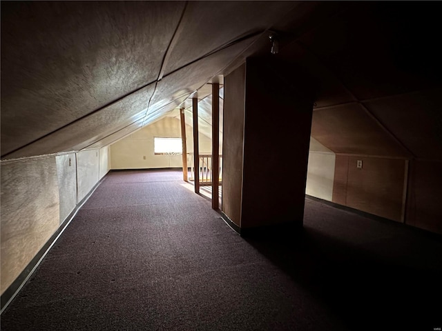 additional living space with lofted ceiling and dark carpet