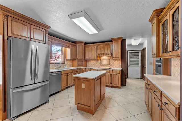 kitchen featuring a center island, tasteful backsplash, sink, appliances with stainless steel finishes, and light tile patterned floors