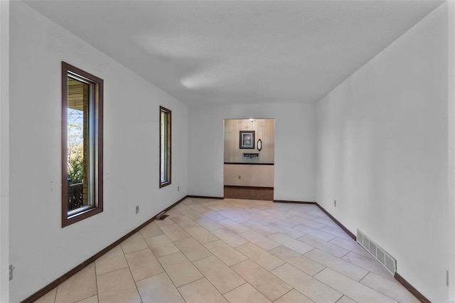 unfurnished room with light tile patterned floors and a textured ceiling