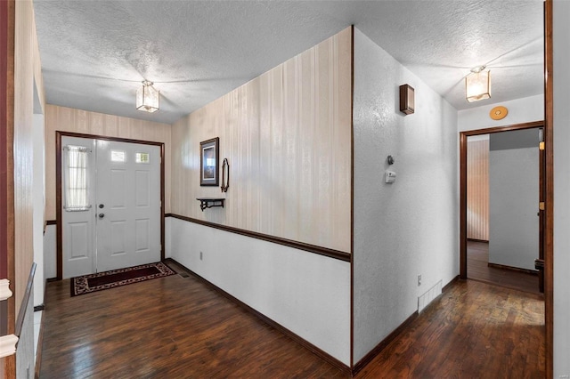 foyer with a textured ceiling and dark wood-type flooring