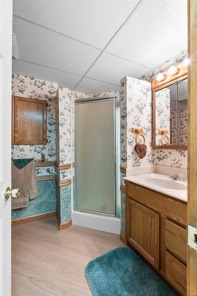 bathroom with vanity, a drop ceiling, hardwood / wood-style floors, and an enclosed shower