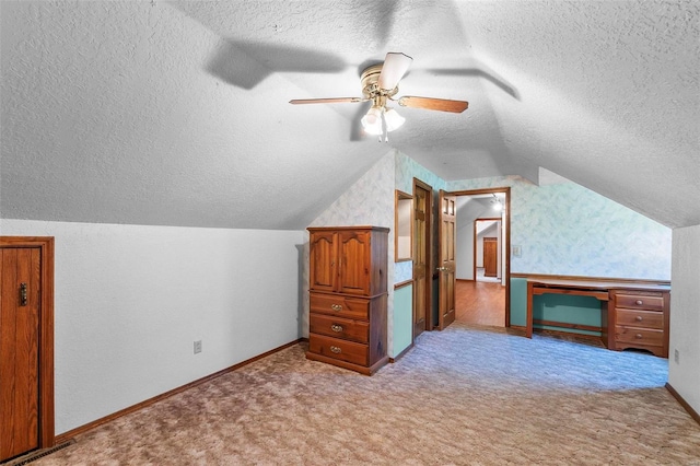 bonus room with ceiling fan, light colored carpet, a textured ceiling, and lofted ceiling