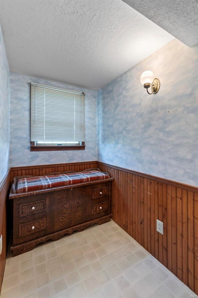 bathroom featuring wood walls and a textured ceiling