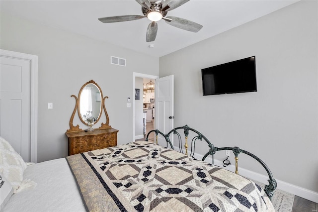 bedroom with ceiling fan with notable chandelier and wood-type flooring