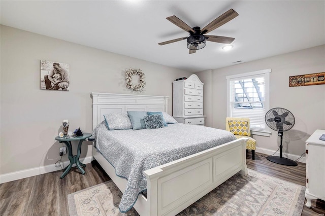 bedroom with dark hardwood / wood-style flooring and ceiling fan