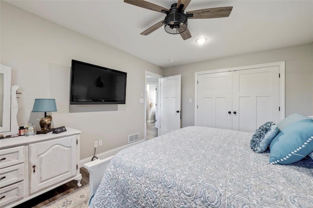 bedroom with ceiling fan, a closet, and dark wood-type flooring