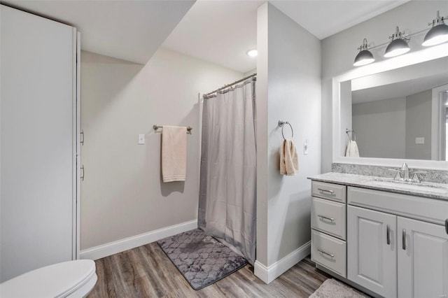 bathroom with hardwood / wood-style flooring, toilet, and vanity