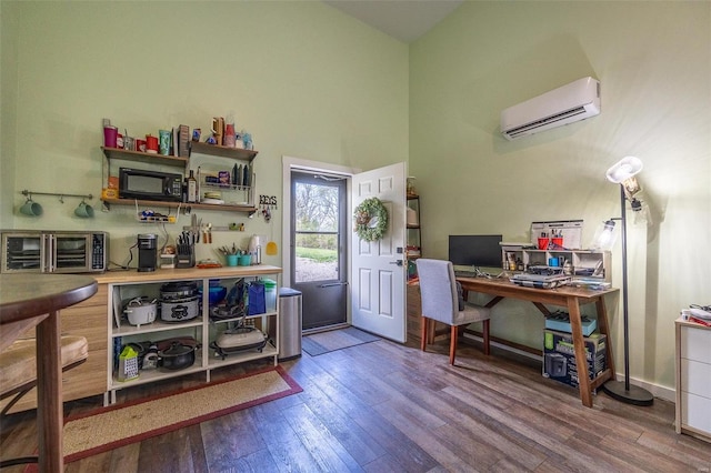 office area with a towering ceiling, a wall mounted air conditioner, and dark hardwood / wood-style flooring