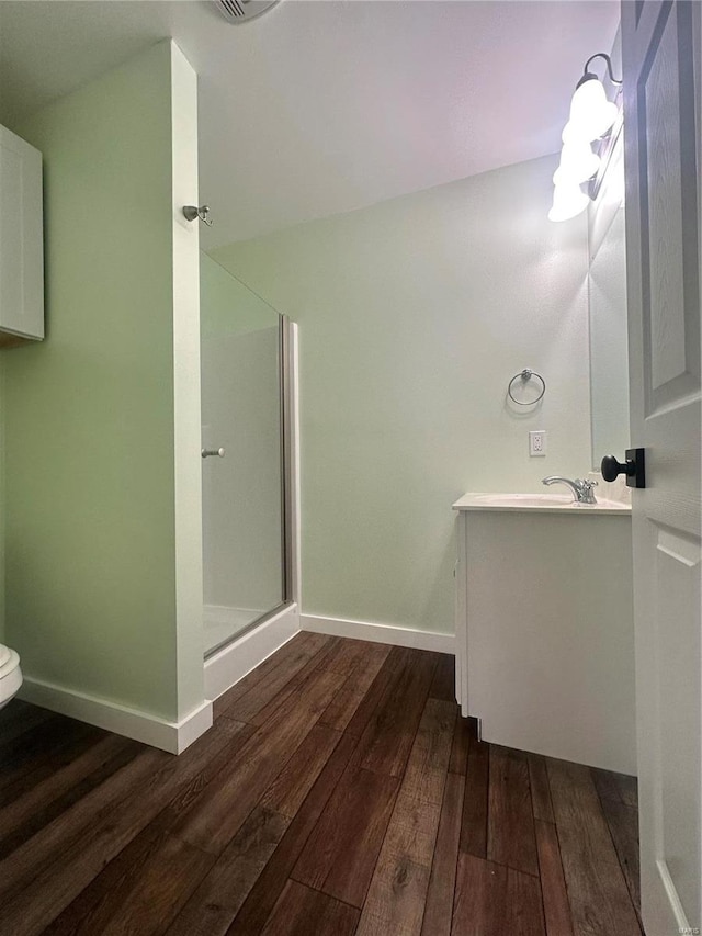 bathroom with walk in shower, toilet, vanity, and wood-type flooring