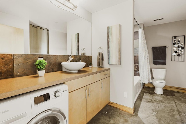 bathroom featuring vanity, toilet, and washer / clothes dryer