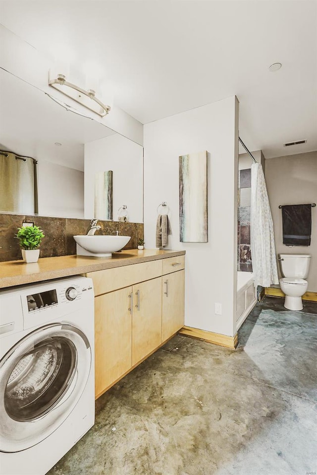 bathroom with vanity, toilet, washer / clothes dryer, and concrete floors