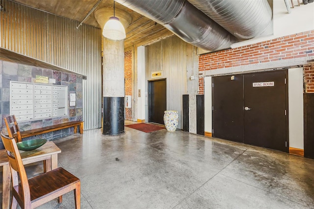 entryway with brick wall, concrete flooring, mail boxes, and wood walls