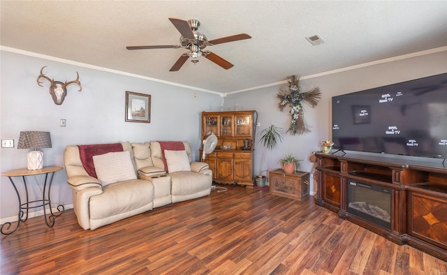 living room with ceiling fan, ornamental molding, dark hardwood / wood-style floors, and a textured ceiling