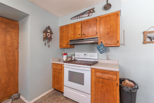 kitchen featuring dark tile flooring and white electric range oven