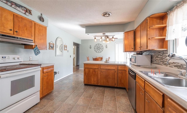 kitchen featuring appliances with stainless steel finishes, dark tile flooring, a wealth of natural light, and sink