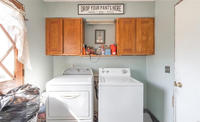 clothes washing area featuring washing machine and clothes dryer and cabinets