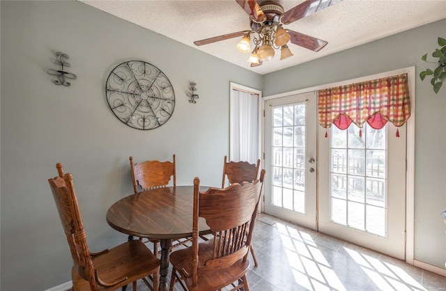 dining area with ceiling fan, french doors, light tile floors, and a textured ceiling