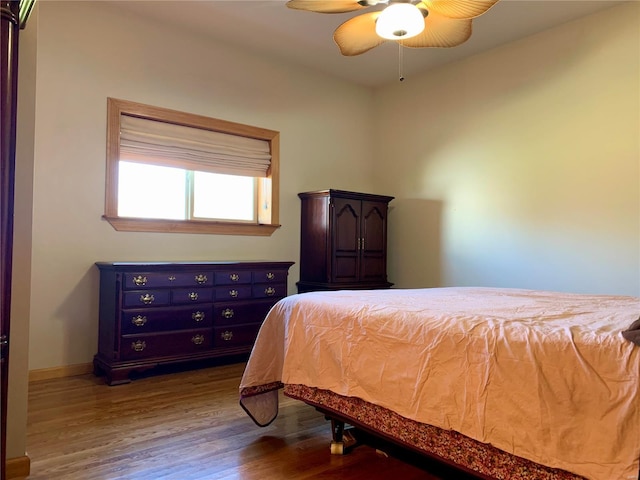 bedroom with dark hardwood / wood-style floors and ceiling fan