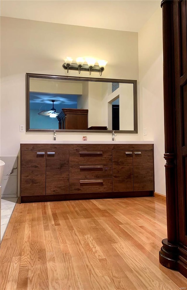 bathroom with hardwood / wood-style flooring, ceiling fan, and vanity