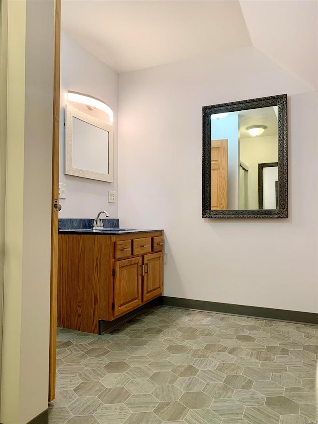 bathroom with lofted ceiling, oversized vanity, and tile flooring