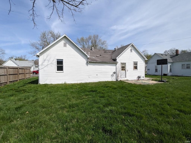 rear view of house featuring a lawn and a patio area