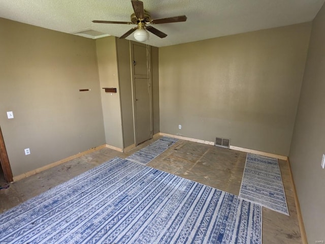 interior space with ceiling fan and a textured ceiling