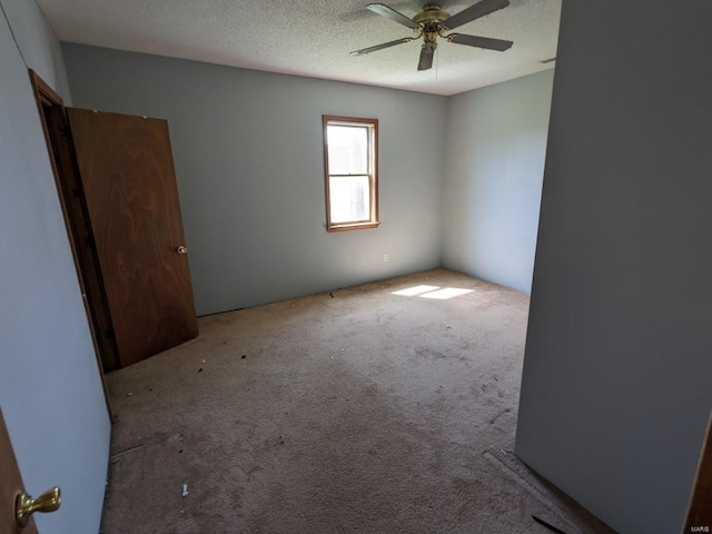 unfurnished room featuring light colored carpet, ceiling fan, and a textured ceiling