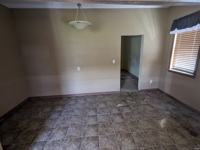 unfurnished room featuring dark tile flooring