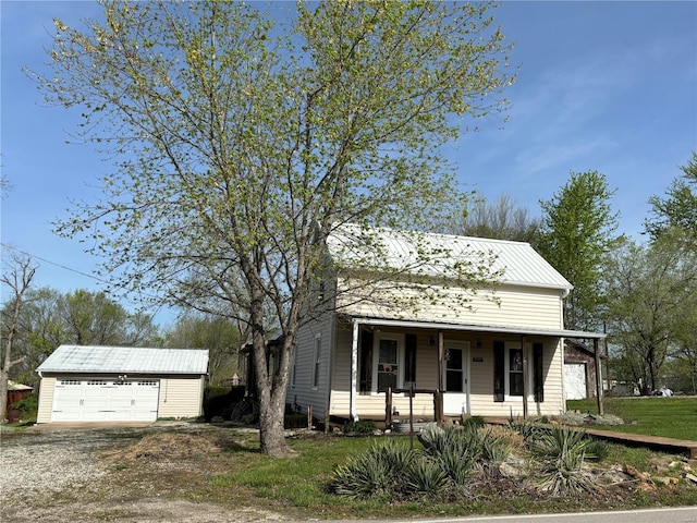 view of front of house featuring a front lawn, covered porch, an outdoor structure, and a garage