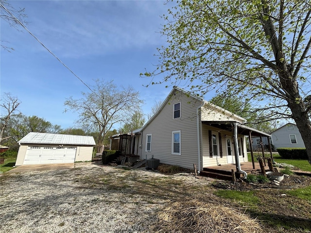 view of home's exterior with an outdoor structure, central air condition unit, and a garage