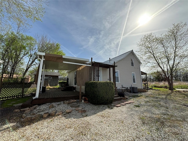 rear view of property with a deck and central AC unit