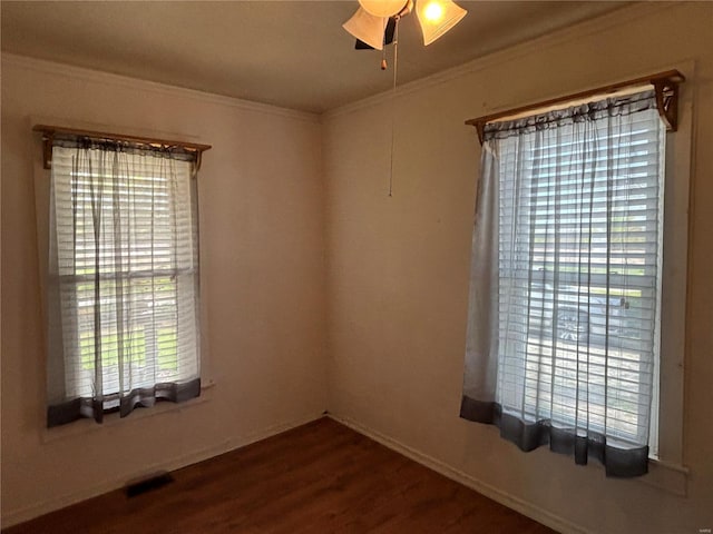 unfurnished room with dark hardwood / wood-style flooring, ceiling fan, and crown molding