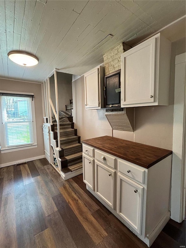 kitchen with dark hardwood / wood-style flooring, white cabinets, wooden ceiling, and butcher block countertops