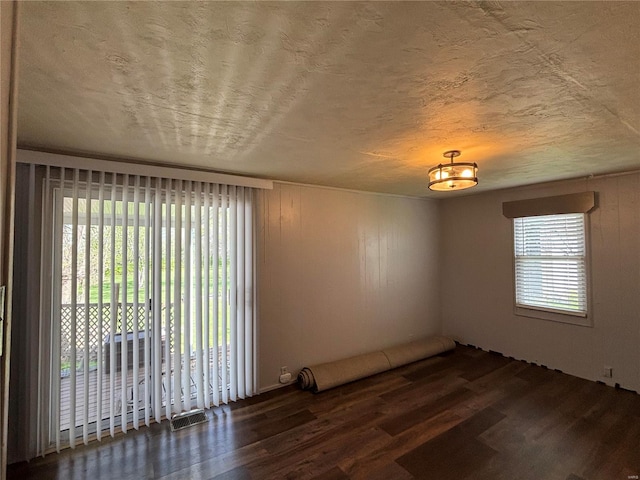 spare room with dark hardwood / wood-style flooring and a textured ceiling